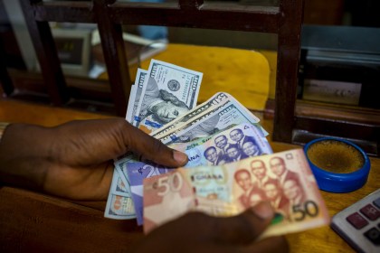 A man trades U.S. dollars for Ghanaian cedis at a currency exchange office in Accra, Ghana, file. REUTERS/Francis Kokoroko